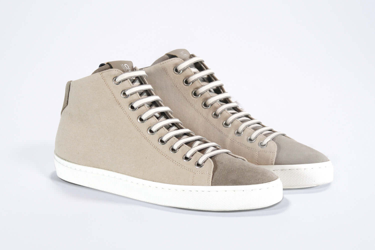 Dreiviertelansicht der Vorderseite von sneaker mit durchgehend beigem Canvas-Obermaterial, innerem Reißverschluss und weißer Sohle.