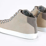 Dreiviertelansicht der Rückseite von sneaker mit beigem Canvas-Obermaterial, innerem Reißverschluss und weißer Sohle.