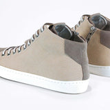 Dreiviertelansicht der Rückseite von sneaker mit beigem Canvas-Obermaterial, innerem Reißverschluss und weißer Sohle.