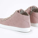 Three quarter back view of mid top sneaker in pink suede and leather upper, internal zip and white sole.