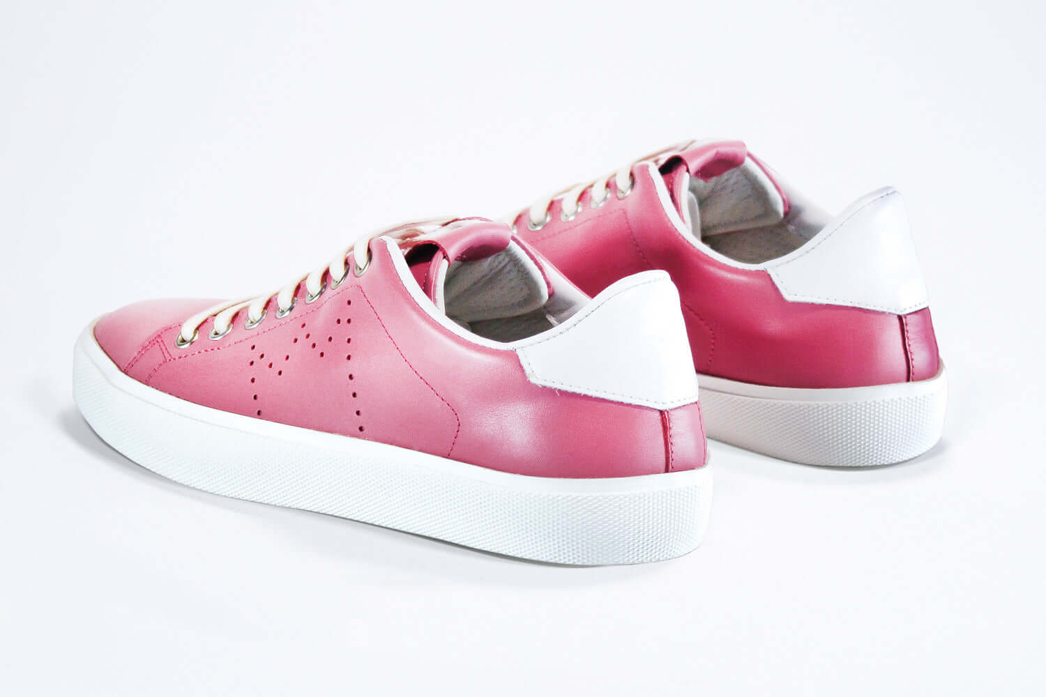 Dreiviertelansicht der Rückseite des rosafarbenen Low Top sneaker mit weißen Details und perforiertem Kronenlogo auf dem Obermaterial. Obermaterial aus Vollleder und weiße Gummisohle.