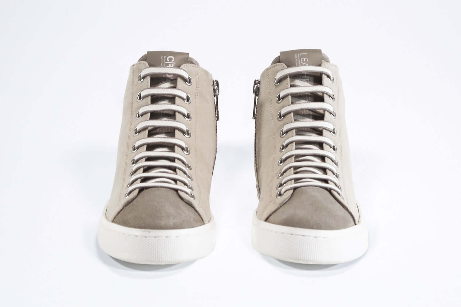 Vorderansicht von sneaker mit durchgehend beigem Canvas-Obermaterial, innerem Reißverschluss und weißer Sohle.