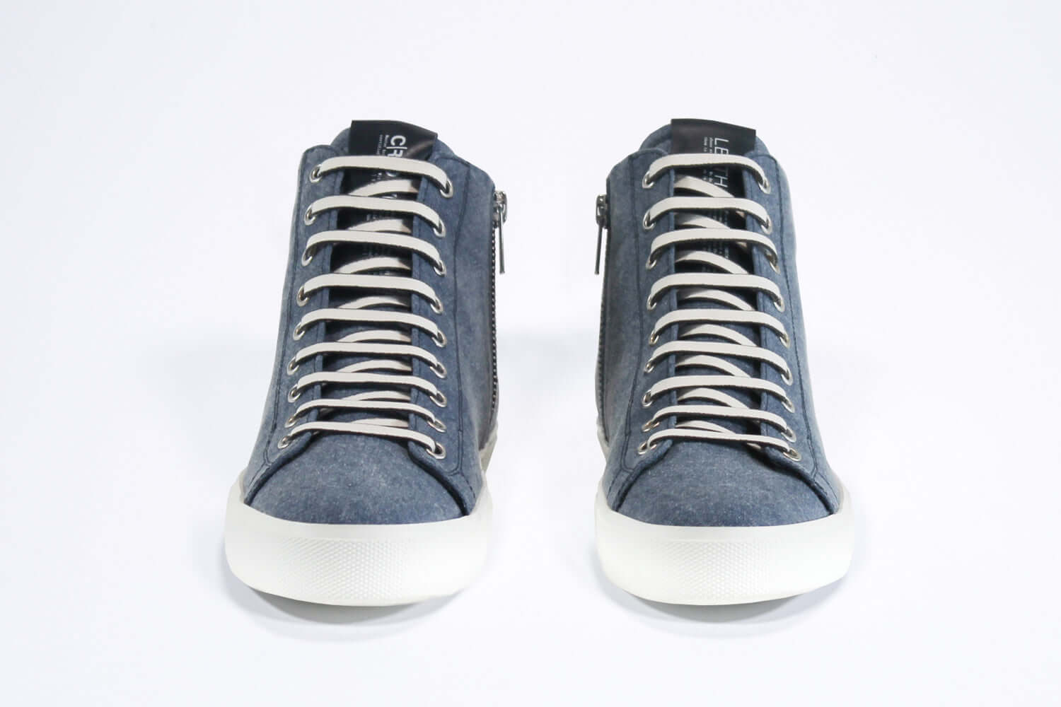 Front view of mid top sneaker in denim blue canvas and leather upper, internal zip and white sole.