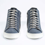 Front view of mid top sneaker in denim blue canvas and leather upper, internal zip and white sole.