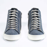 Front view of mid top sneaker in denim blue canvas and leather upper, internal zip and white sole.