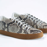 Three quarter front view of low top python skin sneaker. Full snake skin upper and honey coloured rubber sole.