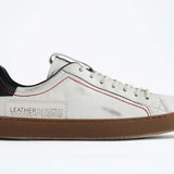 Profilo laterale di una sneaker  BASSE bianca con accenti neri. Tomaia in pelle bianca invecchiata con cuciture rosse e suola in gomma scura.