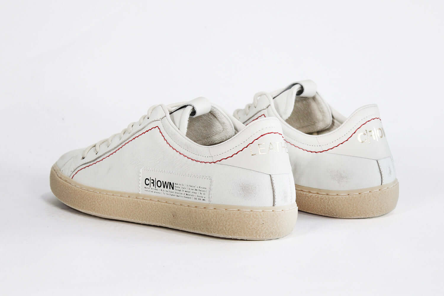 Vista posteriore della sneaker BASSE bianca. Tomaia in pelle bianca invecchiata con cuciture rosse e suola in gomma naturale.