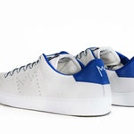 Back view of low top white sneaker with blue detailing and perforated crown logo on upper. Full leather upper and white rubber sole.