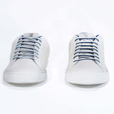 Front view of low top white sneaker with blue detailing and perforated crown logo on upper. Full leather upper and white rubber sole.