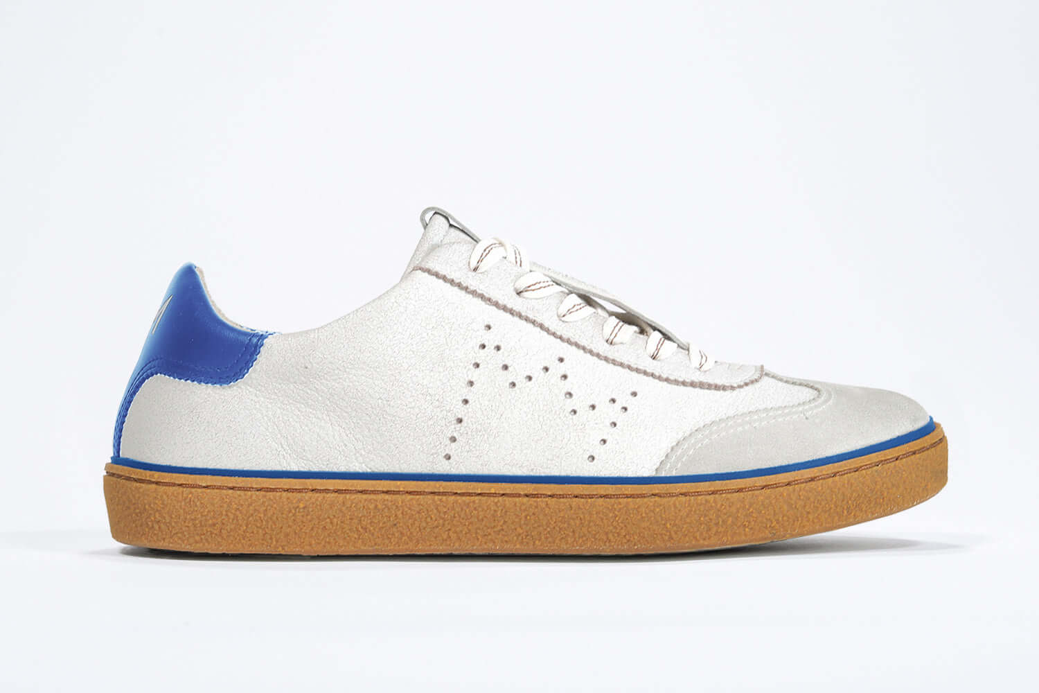 Side view of low top retro sneaker in distressed white leather with blue detailing and honey coloured recycled rubber sole.