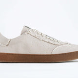Side view of low top retro sneaker in distressed stone canvas, with honey coloured recycled rubber sole.