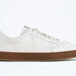 Seitenansicht eines sneaker aus weißem Canvas mit honigfarbener Sohle aus recyceltem Gummi.