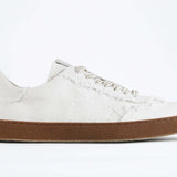 Seitenansicht eines sneaker aus weißem Canvas mit honigfarbener Sohle aus recyceltem Gummi.