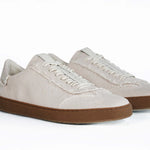 Three quarter front view of low top retro sneaker in distressed stone canvas, with honey coloured recycled rubber sole.