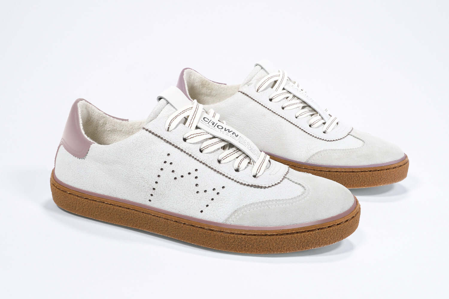 Three quarter front view of low top retro sneaker in distressed white leather with peach detailing and honey coloured recycled rubber sole.