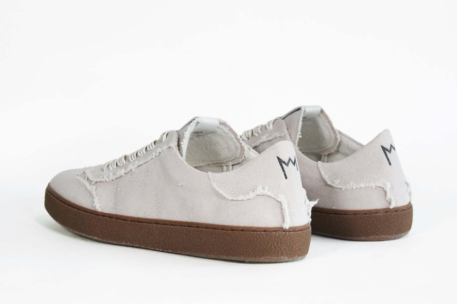 Back view of low top retro sneaker in distressed stone canvas, with honey coloured recycled rubber sole.