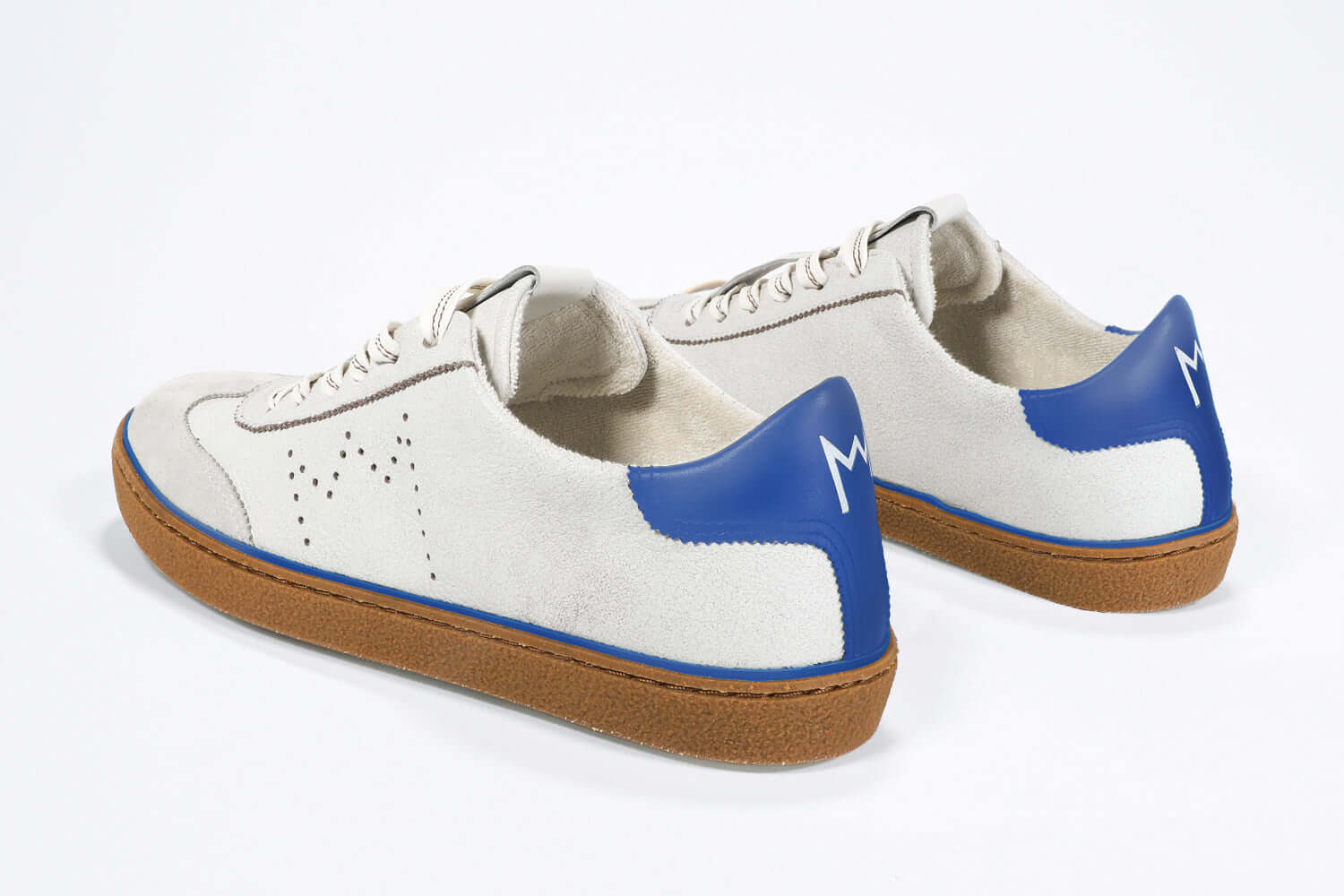 Back view of low top retro sneaker in distressed white leather with blue detailing and honey coloured recycled rubber sole.