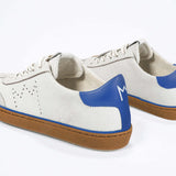 Back view of low top retro sneaker in distressed white leather with blue detailing and honey coloured recycled rubber sole.