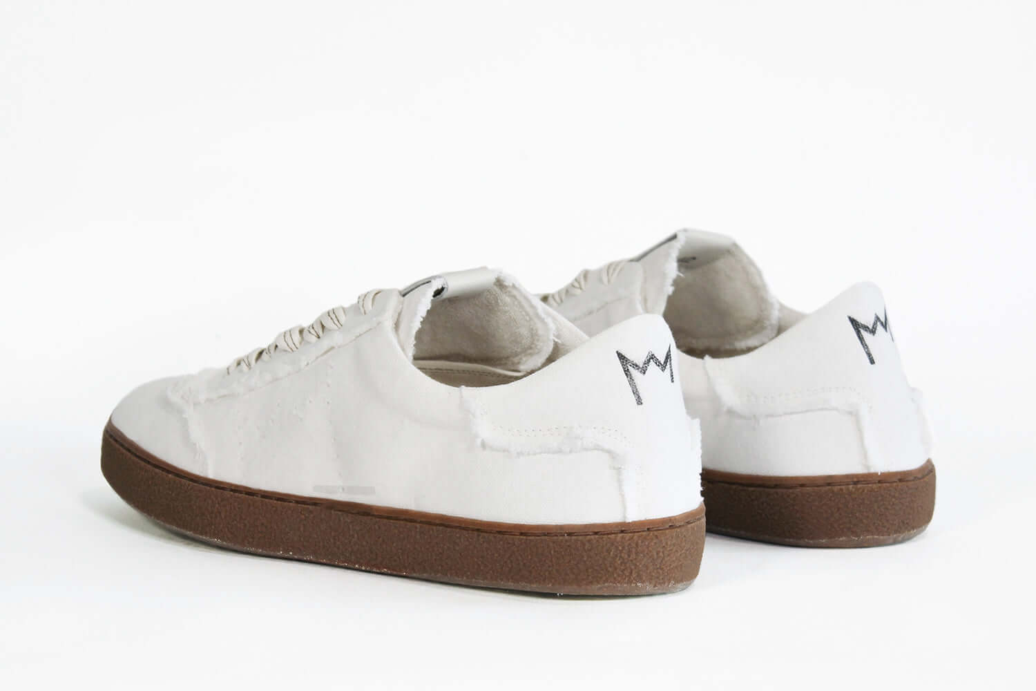 Rückansicht eines sneaker aus weißem Canvas mit honigfarbener Sohle aus recyceltem Gummi.