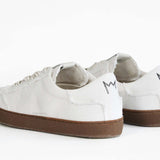 Rückansicht eines sneaker aus weißem Canvas mit honigfarbener Sohle aus recyceltem Gummi.