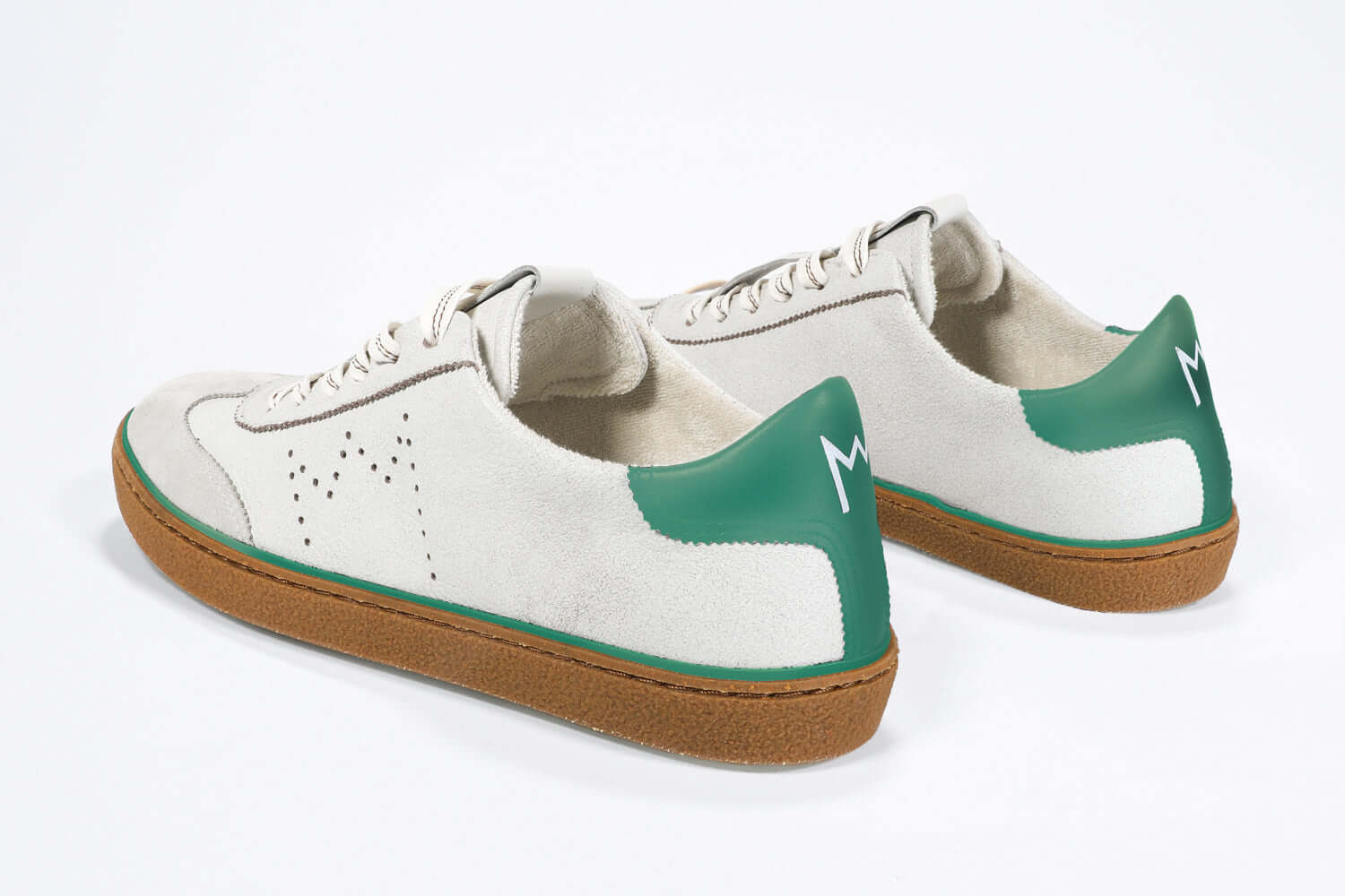 Back view of low top retro sneaker in distressed white leather with green detailing and honey coloured recycled rubber sole.