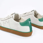 Back view of low top retro sneaker in distressed white leather with green detailing and honey coloured recycled rubber sole.