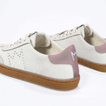 Back view of low top retro sneaker in distressed white leather with peach detailing and honey coloured recycled rubber sole.