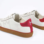 Back view of low top retro sneaker in distressed white leather with red detailing and honey coloured recycled rubber sole.
