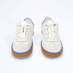 Front view of low top retro sneaker in distressed white leather with blue detailing and honey coloured recycled rubber sole.