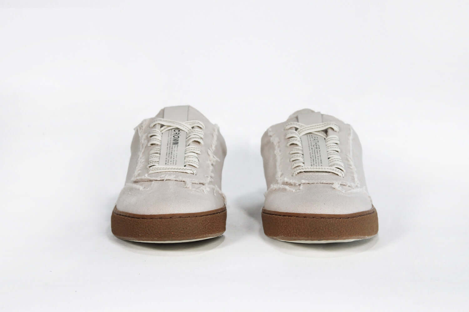 Front view of low top retro sneaker in distressed stone canvas, with honey coloured recycled rubber sole.