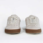 Front view of low top retro sneaker in distressed stone canvas, with honey coloured recycled rubber sole.
