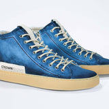 Three quarter front view of high top canvas sneaker. Canvas upper hand painted in gradated blue paint. Pale natural rubber sole.