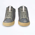 Front view of high top perforated aged grey leather sneaker with signature red stitching and a dark natural rubber sole.