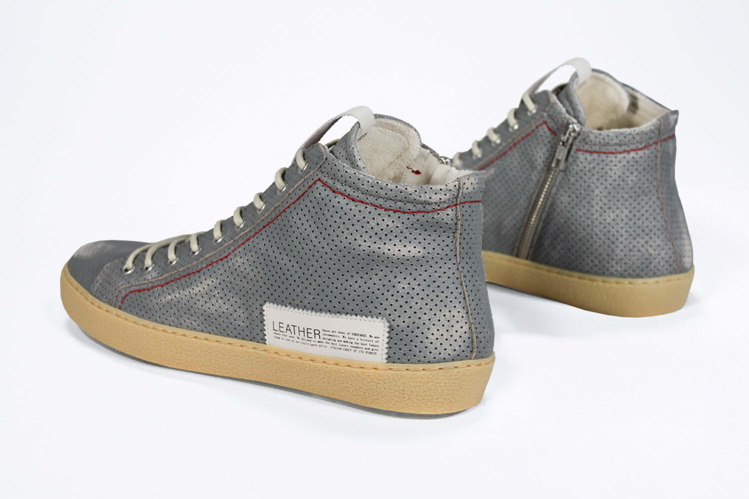 Back view of high top perforated aged grey leather sneaker with signature red stitching and a dark natural rubber sole.