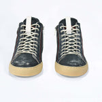 Front view of high top perforated aged navy leather sneaker with signature red stitching and a pale natural rubber sole.