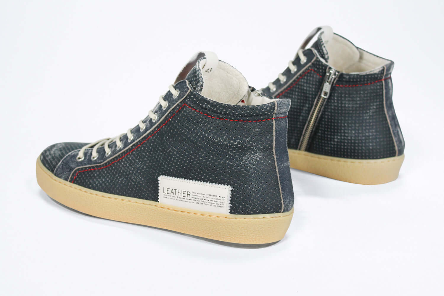 Back view of high top perforated aged navy leather sneaker with signature red stitching and a pale natural rubber sole.