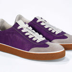 Three quarter front view of low top retro sneaker in distressed violet leather with white and grey detailing and honey coloured recycled rubber sole.