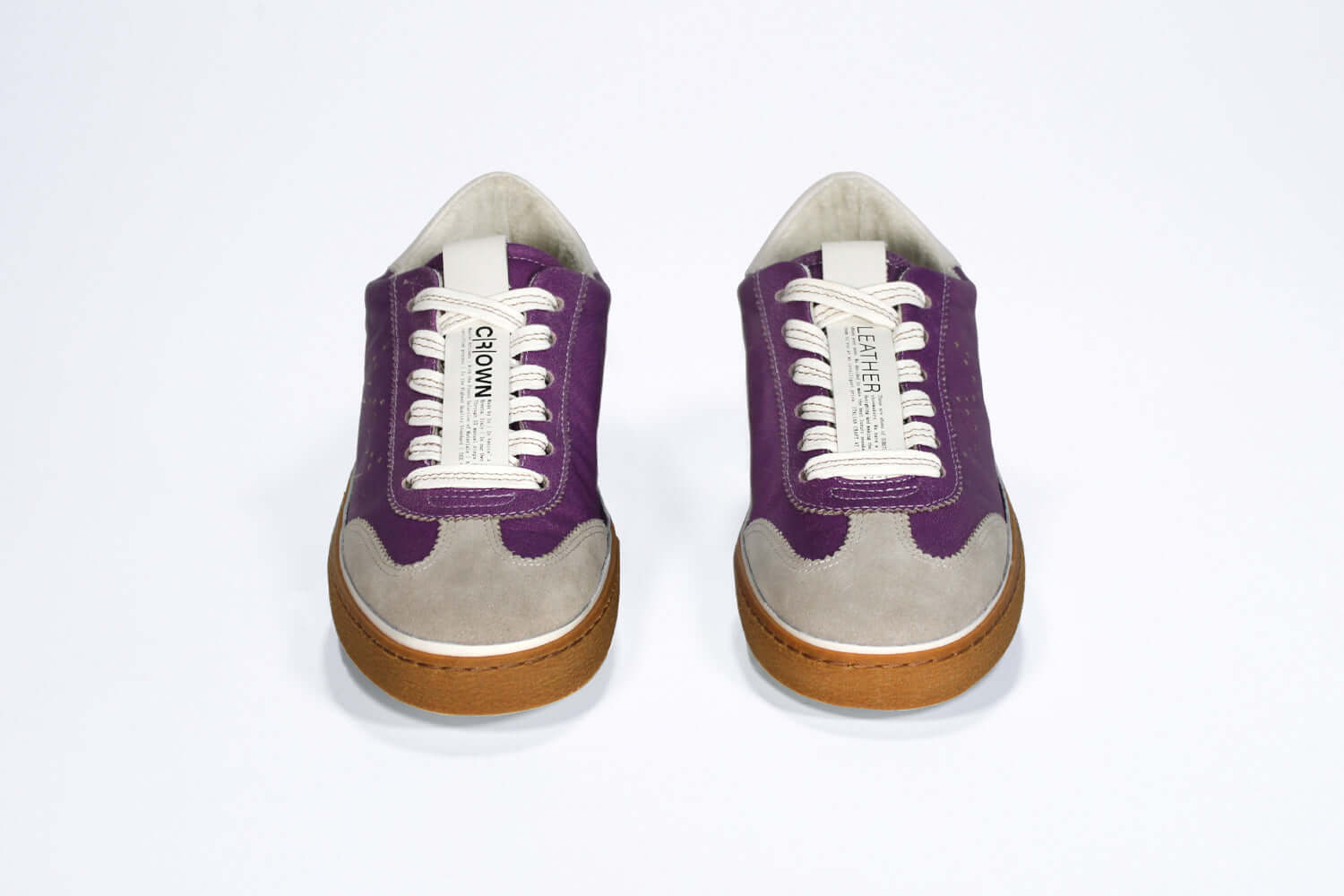 Front view of low top retro sneaker in distressed violet leather with white and grey detailing and honey coloured recycled rubber sole.