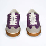 Front view of low top retro sneaker in distressed violet leather with white and grey detailing and honey coloured recycled rubber sole.