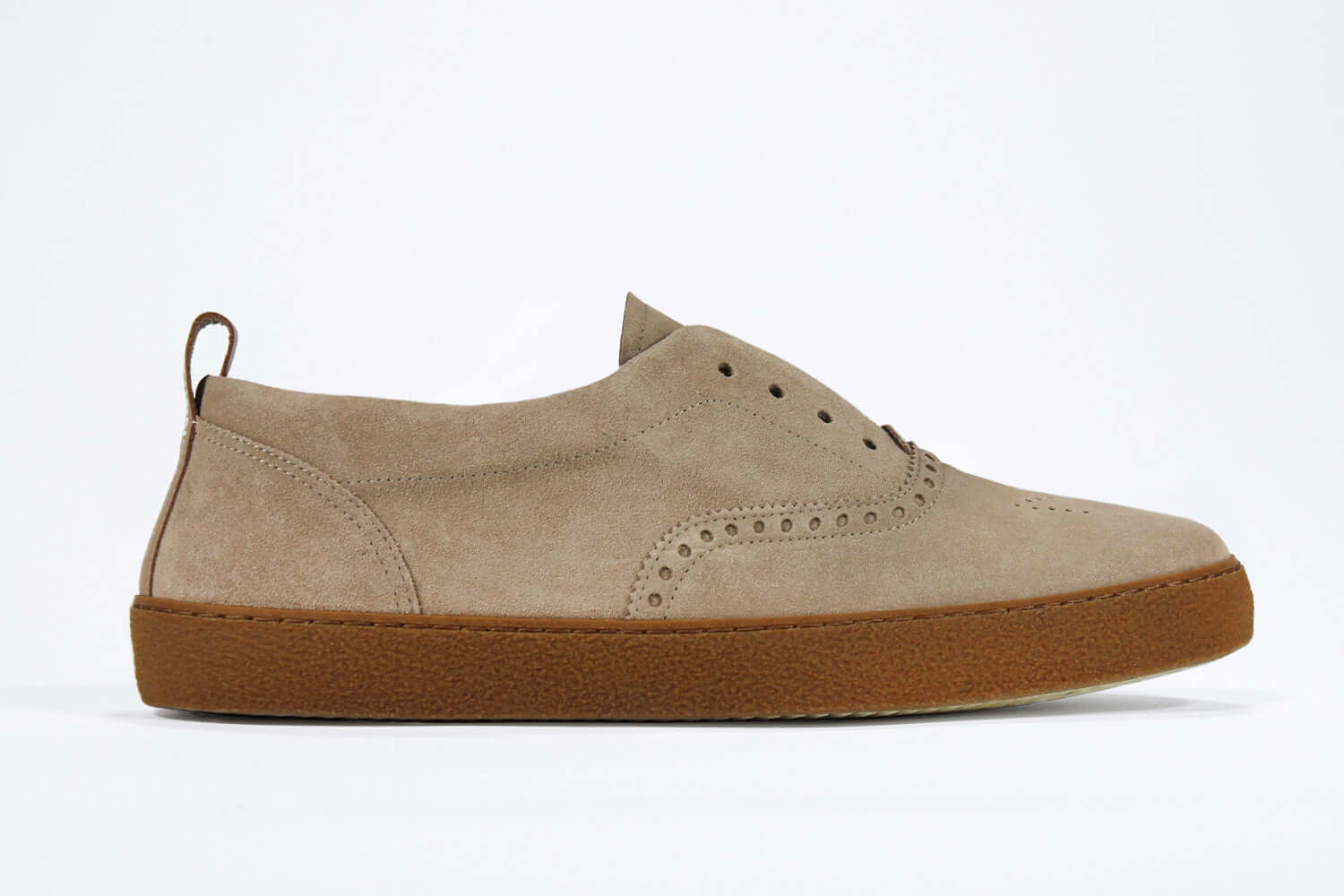 Side view of loafer style sneaker. Camel suede upper with perforated crown logo, elasticated tongue and a honey coloured recycled rubber sole.