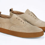 Three quarter front view of loafer style sneaker. Camel suede upper with perforated crown logo, elasticated tongue and a honey coloured recycled rubber sole.