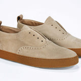 Three quarter front view of loafer style sneaker. Camel suede upper with perforated crown logo, elasticated tongue and a honey coloured recycled rubber sole.