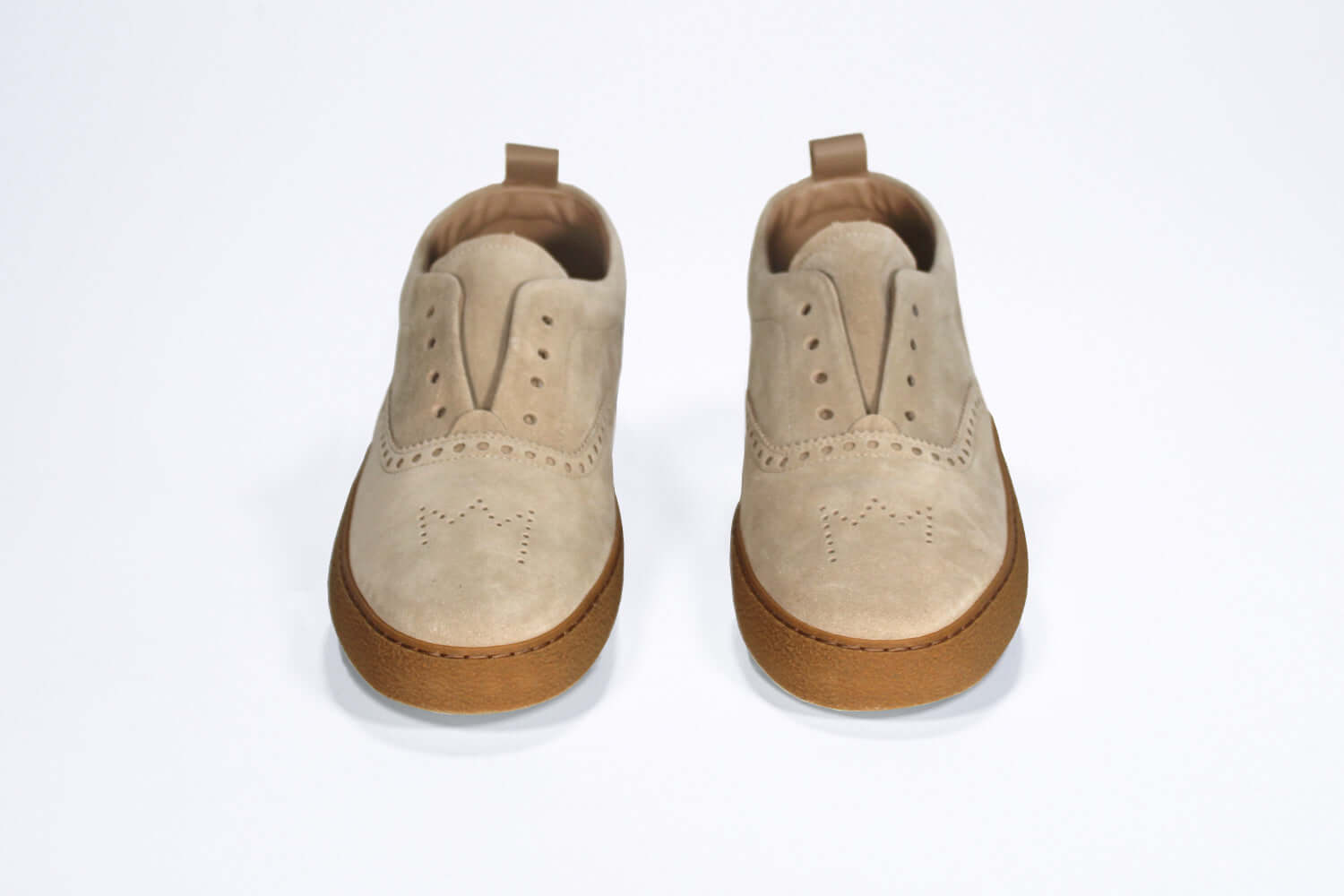 Front view of loafer style sneaker. Camel suede upper with perforated crown logo, elasticated tongue and a honey coloured recycled rubber sole.