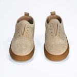 Front view of loafer style sneaker. Camel suede upper with perforated crown logo, elasticated tongue and a honey coloured recycled rubber sole.