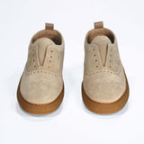 Front view of loafer style sneaker. Camel suede upper with perforated crown logo, elasticated tongue and a honey coloured recycled rubber sole.