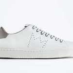 Profilo laterale di BASSE bianco sneaker con dettagli beige e logo della corona traforato sulla tomaia. Tomaia in pelle e suola in gomma bianca.