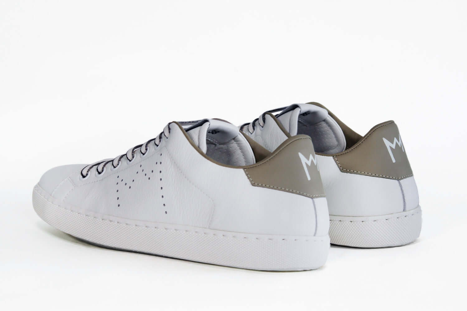 Back view of low top white sneaker with beige detailing and perforated crown logo on upper. Full leather upper and white rubber sole.