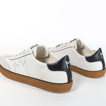 Back view of low top retro sneaker in distressed white leather with black detailing and honey coloured recycled rubber sole.