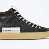 Side profile of high top sneaker. Perforated distressed black leather sneakers with signature red stitching and pale natural rubber sole.